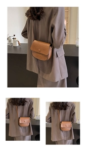 Detail view of a vintage brown saddle bag featuring lychee grain leather and magnetic buckle