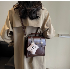 Detailed back view of a retro dark brown leather backpack with a pink star plush charm