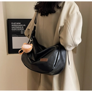 Détail du sac croissant noir avec bandoulière réglable et porte-clé peluche mignon