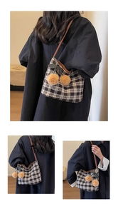 Gros plan du sac cabas à carreaux noir et blanc avec breloques cerises et bandoulière