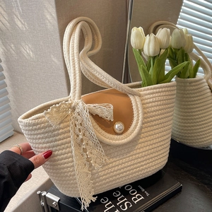 Handwoven straw tote bag with leather flap, pearl clasp, and delicate lace bow detail