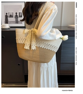 Détail du grand sac cabas tissé avec nœud en dentelle blanche et décoration florale