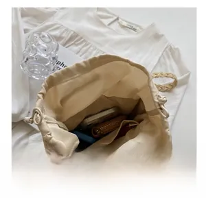 Spacious interior of woven bucket bag with canvas drawstring lining and daily essentials