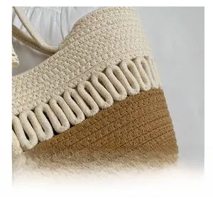 Détail du sac de plage tissé bicolore montrant le tressage contrasté beige et beige