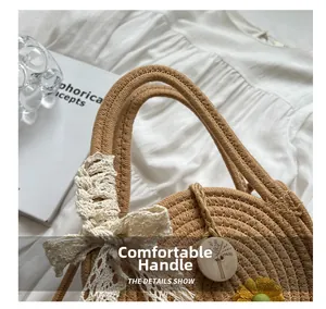 Detail der Strohtasche mit Spitzenschleife, Sonnenblumen-Patch und rundem Holzanhänger