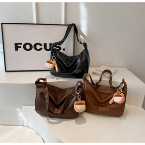 Détail de sacs vintage en cuir PU en noir, marron foncé et couleurs caramel chic