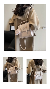 Detail showing versatile beige retro backpack with detachable straps and plush charm