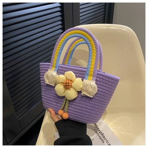 Detail of purple woven tote bag with yellow sunflower and rainbow braided handle