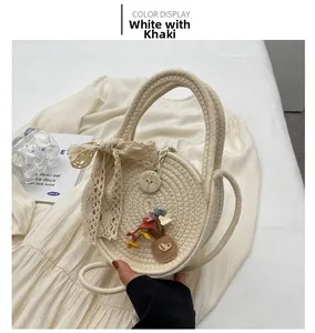 Détail d'un sac rond tissé à la main avec nœud en dentelle et fleurs en blanc et kaki