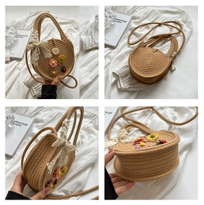 Detail der runden Strohtasche mit Blumenstickerei und Spitzenschleife auf weißem Stoff