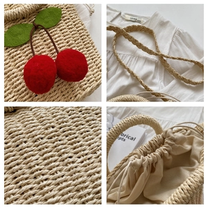 Detail of hand-woven straw bag with red felt cherry charms and drawstring lining