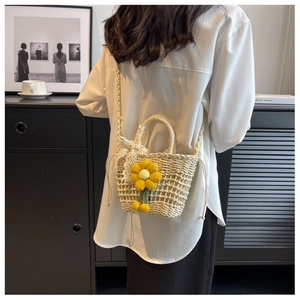 Detail of straw woven bag featuring sunflower decor and lace bow on a model's back