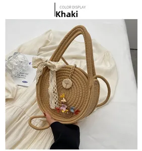 Détail du sac rond en paille avec nœud en dentelle et ornements floraux