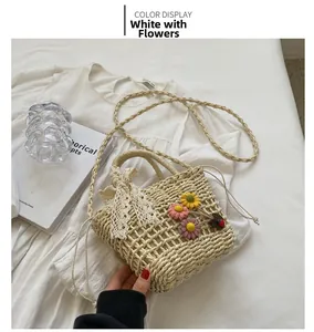 Close-up of handmade beige woven straw bag with colorful crochet flowers and lace bow