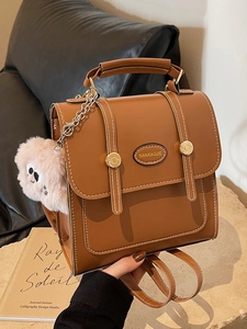 Vintage caramel faux leather mini backpack with white stitching and plush monster charm