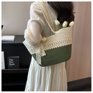Détail d'un cabas de plage tissé à la main avec dentelle verte et nœud décoratif