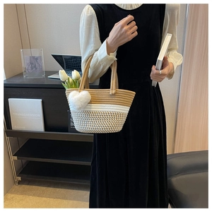 Detailansicht der handgewebten Tasche mit Herzanhänger und weißen Deko-Tulpen