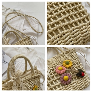 Detail of handmade woven straw bag with floral accents and lace bow decorations