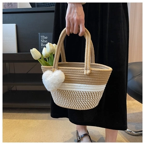 Detail der gewebten Korbtasche mit Herzanhänger und Tulpen in einer Lifestyle-Umgebung