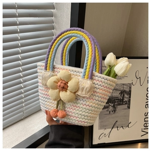 Detail of woven straw handbag with colorful wave stitching and floral cherry charms