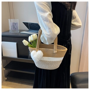 Detail der handgewebten Korbtasche mit Herzanhänger und dekorativen Tulpen
