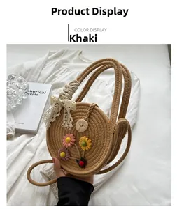 Detail einer handgewebten Strohtasche mit bunten Blumen und Spitzenschleife