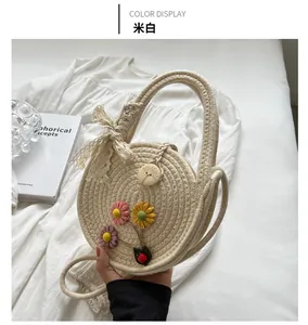 Detail der beigen handgewebten Tasche mit 3D-Blumenakzenten und weißer Spitzen-Schleife