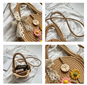 Detailansicht der Strohtasche mit Spitzenschleife und farbenfrohen Gänseblümchen-Akzenten