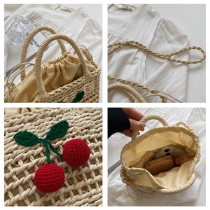 Detail of handmade straw bag featuring crochet cherry decor and drawstring lining texture