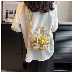 Detail of handmade woven straw bucket bag with floral crochet and lace bow accent