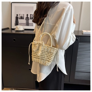 Detail of handmade straw tote bag with lace bow decoration and drawstring closure