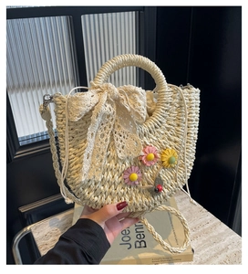 Detail of hand-woven straw bag with lace bow, floral accents and drawstring lining
