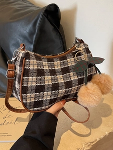 Classic plaid canvas shoulder bag with brown leather trim and cherry plush charm accessory