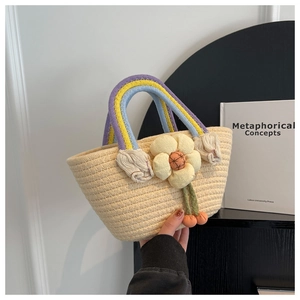 Detail of woven straw handbag with colorful rainbow handle and yellow flower pendant