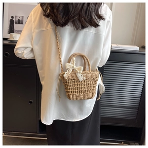 Detailed view of handmade woven straw bag with lace bow and dual strap functionality