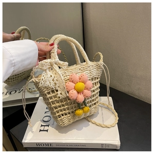 Detail of beige straw bucket bag with crochet flowers and white lace bow decoration