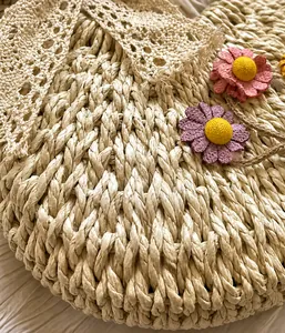 Macro detail of hand-woven straw bag with lace trim and handmade fabric daisy flowers