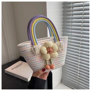 Detail of woven straw bag with rainbow handles and a yellow 3D floral decoration