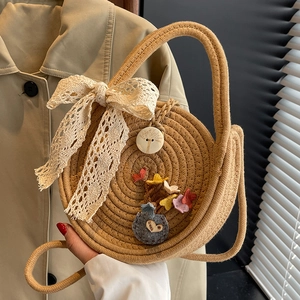 Sac bandoulière rond en paille avec nœud en dentelle blanche et breloques colorées