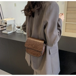 Close-up detail of the retro brown crossbody bag with textured leather and buckle