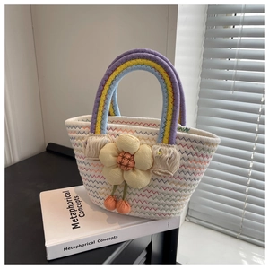 Detail of hand-woven white summer tote with rainbow handle and 3D floral accent