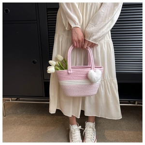 Detail der handgewebten Baumwoll-Eimertasche mit rosa Streifen und Herz-Anhänger