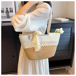 Détail du sac de plage tissé montrant la texture en coton et le nœud en dentelle blanche