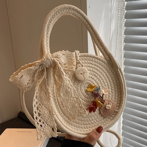 Sac à main chic en paille tissée beige avec nœud en dentelle et breloque florale