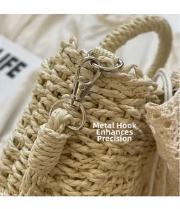 Detail of silver metal hook and fine woven texture on beige straw handbag