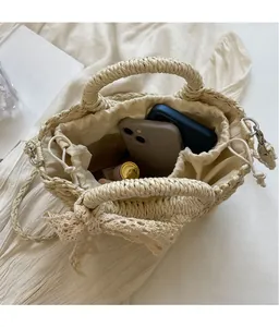 Interior view of beige woven bucket bag showing space for phones and lipstick