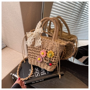 Macro view of handmade straw beach bag with floral decor and lace bow detailing