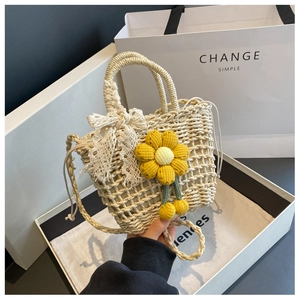 Detail of handmade woven tote bag with lace bow and yellow sun flower pendant