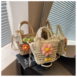 Detail of straw woven bags with large knit flowers, lace bows and drawstring lining