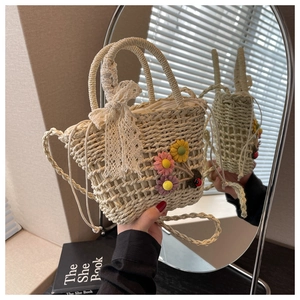 Detail of handwoven straw bag with lace bow, crochet flowers and drawstring lining